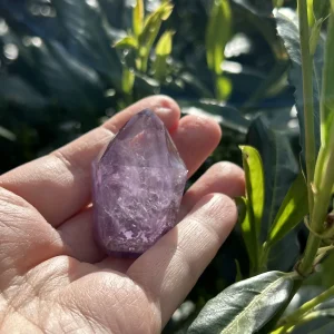Amethyst Spitze frontal fotografiert vor blauem Himmel mit Wolken