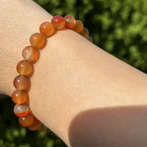 Karneol Armband mit 8 mm Kugeln am Handgelenk, leuchtend im Sonnenlicht