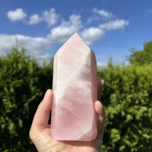 Große Rosenquarz Skulptur vor blauem Himmel mit weißen Wolken